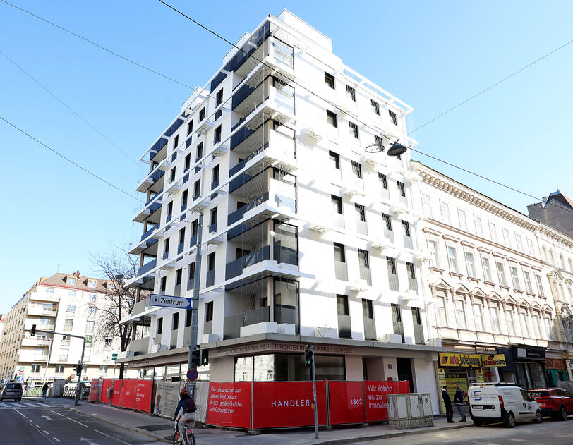 Außenansicht vom Gemeindebau Neu in der Schönbrunnerstraße. Das Foto zeigt eine Ansicht vom 5 mit Bilick in Richtung 6. Bezirk, es sind zwei Seiten des Gebäudes erkennbar, es gibt zahlreiche Balkone