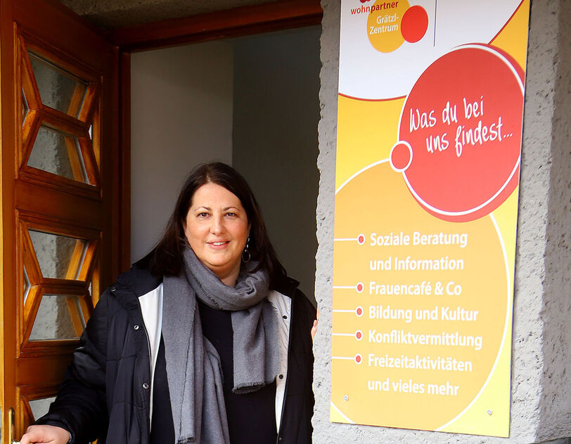 Kathrin Gaál steht in der Tür eines Wohnpartner Grätzl-Zentrums. Sie hat braune lange Haare und trägt herbstliche Kleidung.