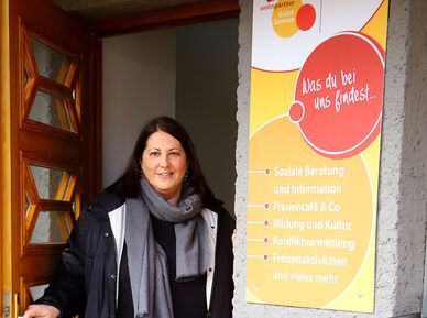 Kathrin Gaál steht in der Tür eines Wohnpartner Grätzl-Zentrums. Sie hat braune lange Haare und trägt herbstliche Kleidung.