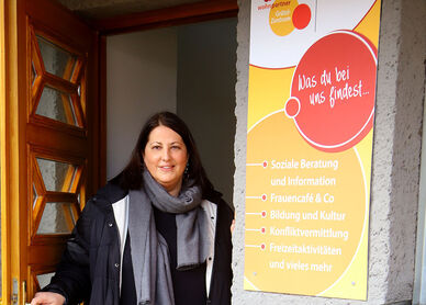 Kathrin Gaál steht in der Tür eines Wohnpartner Grätzl-Zentrums. Sie hat braune lange Haare und trägt herbstliche Kleidung.