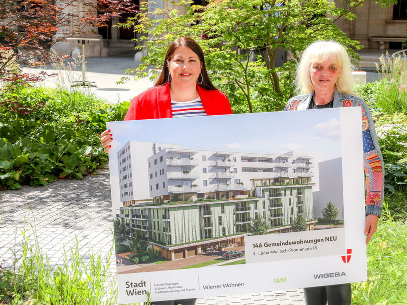Vizebürgermeisterin Kathrin Gaal hält gemeinsam mit der Bezirksvorsteher-Stellvertreterin des dritten Bezirks, Susanne Wessely eine Tafel, die eine Visualisierung des Gemeindebau NEU im Village im Dritten zeigt.